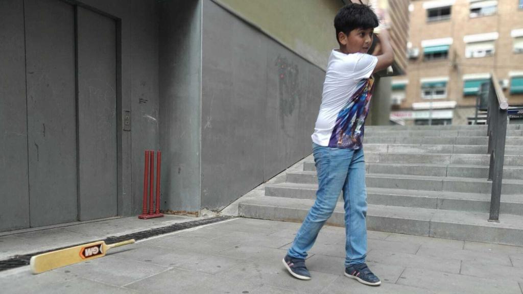 Un niño indio juega a cricket en una calle del barrio del Fondo.