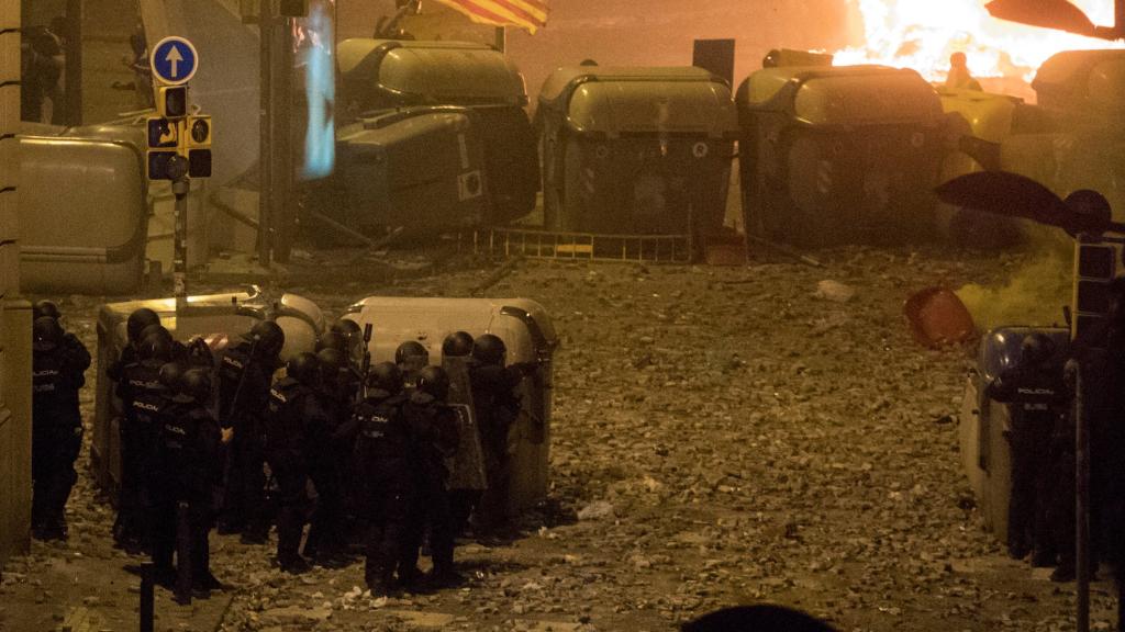 Un grupo de policías en los disturbios de Barcelona, rodeados de cascotes arrojados por los violentos.