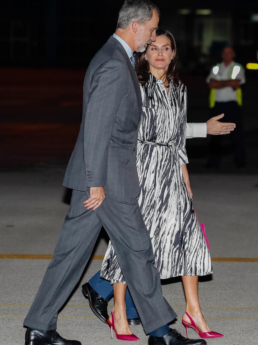 La Reina ha lucido un bolso de mano fucsia combinado con unos salones.