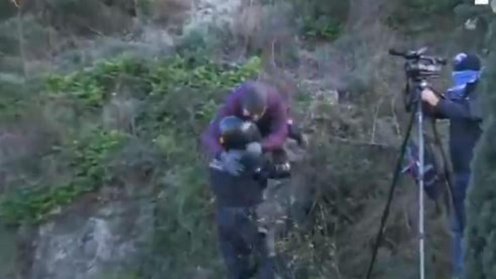 Manifestante lanzándose sobre un agente.