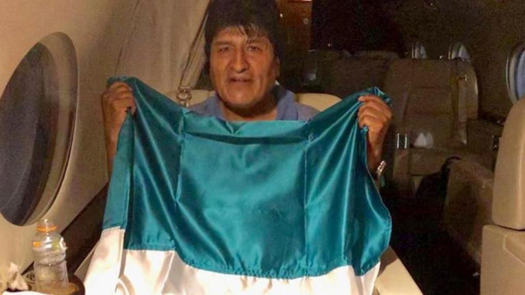 Evo Morales posa con la bandera de Bolivia dentro del avión, camino a México.