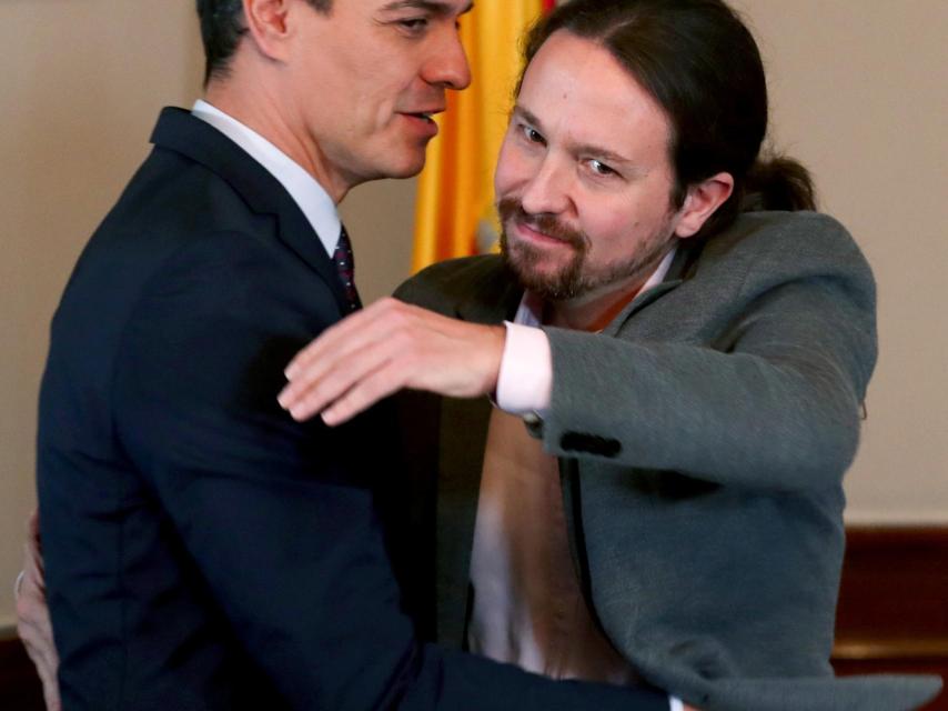 Pedro Sánchez mira de reojo a Pablo Iglesias en el abrazo con el que sellaron su acuerdo de Gobierno.