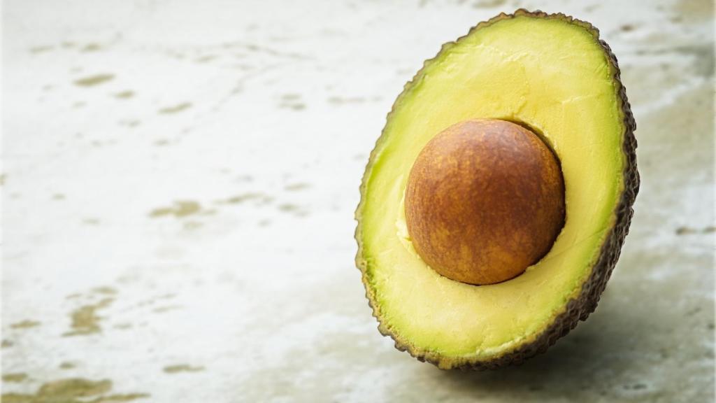 Un aguacate cortado por la mitad.