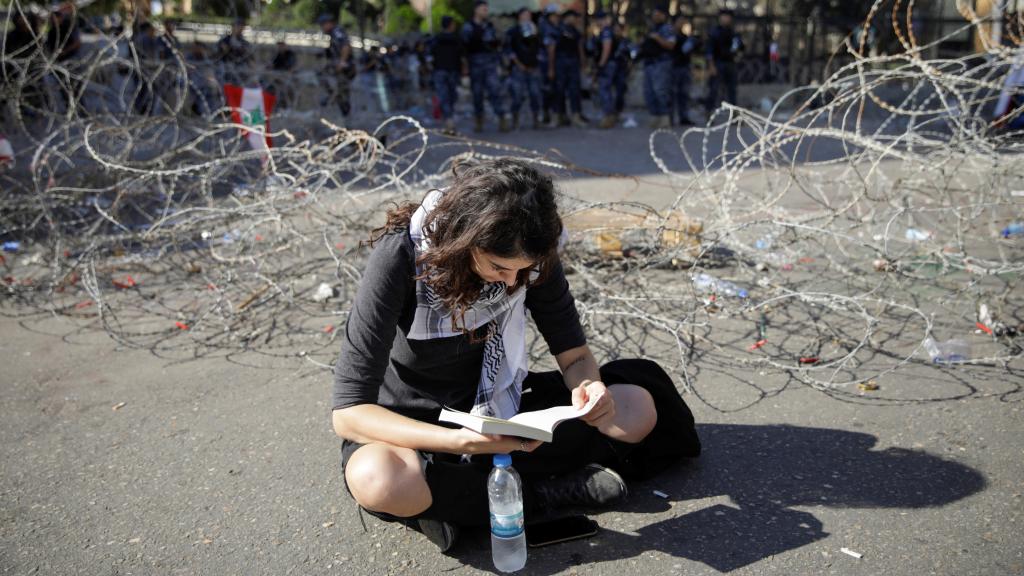 Una joven libanesa lee un libro en medio de una protesta contra el Gobierno.