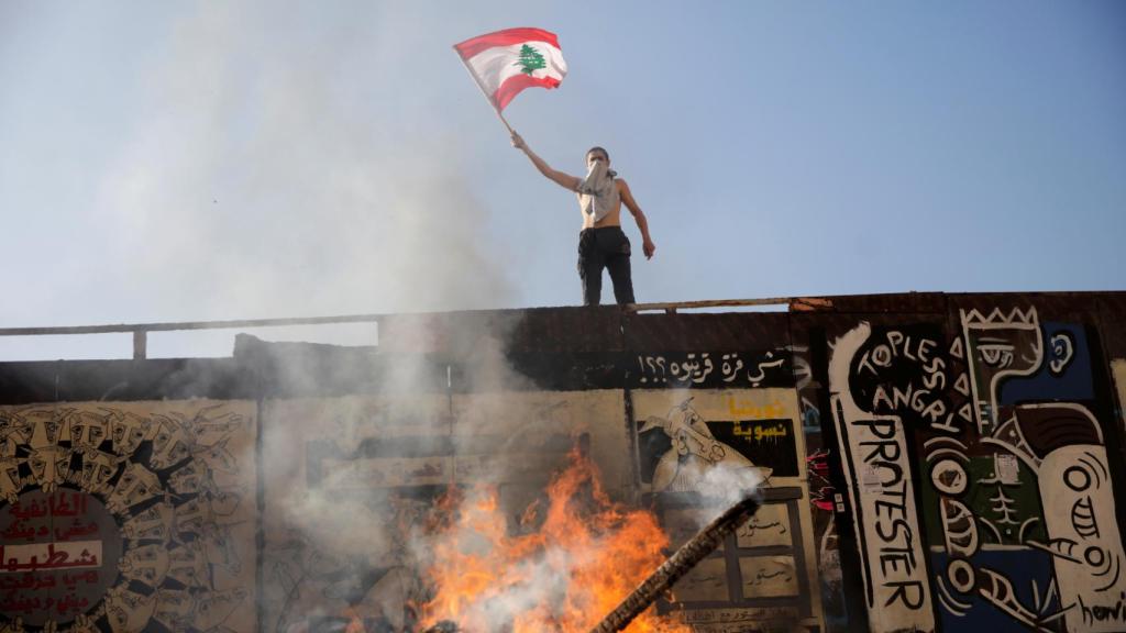 Un joven enarbola la bandera del país durante las protestas.