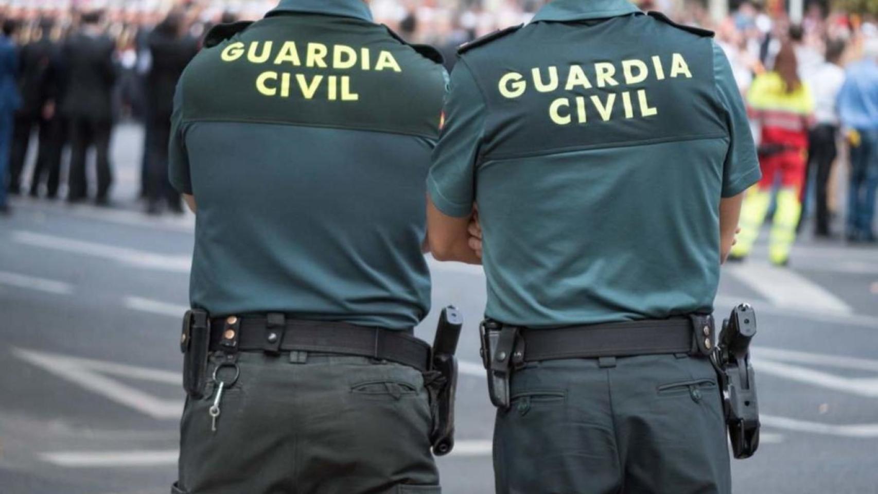 Dos agentes de la Guardia Civil de espaldas.