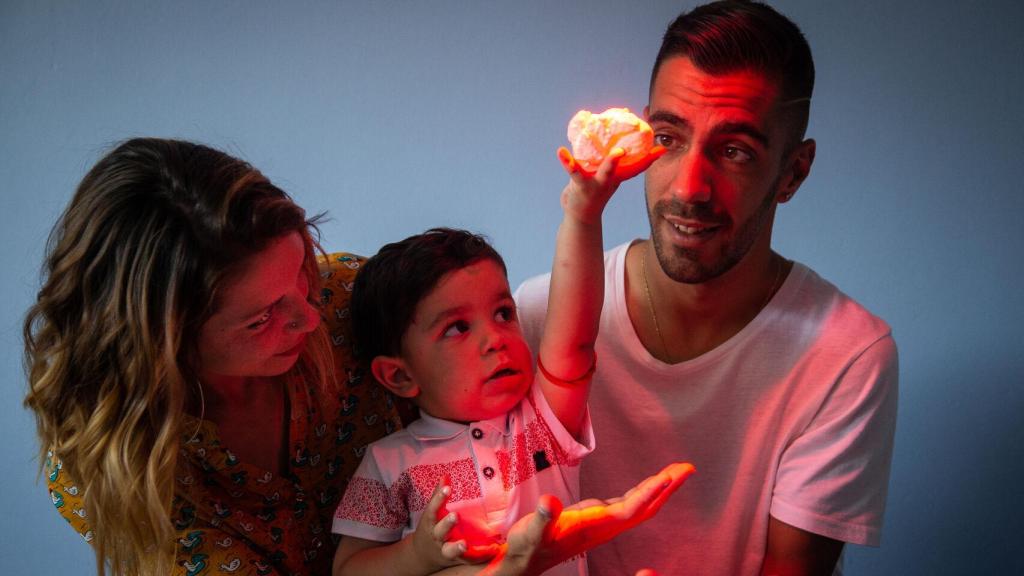 El pequeño Adríán, en brazos de sus padres, sosteniendo una recreación de su propio corazón impreso en tres dimensiones.