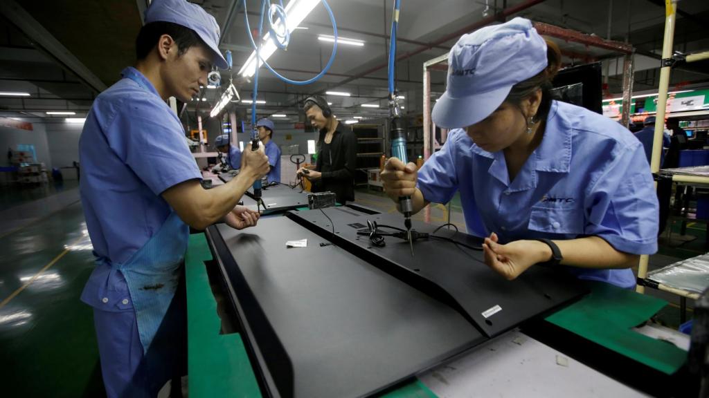 Empleados de Zhaochi Group fabricando una televisión