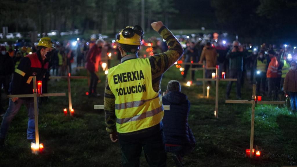 Un trabajador levanta el brazo como signo de protesta durante un velatorio nocturno simbólico.