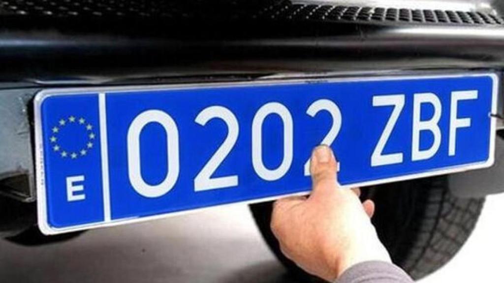 Un hombre poniendo su matrícula en perfecto estado.