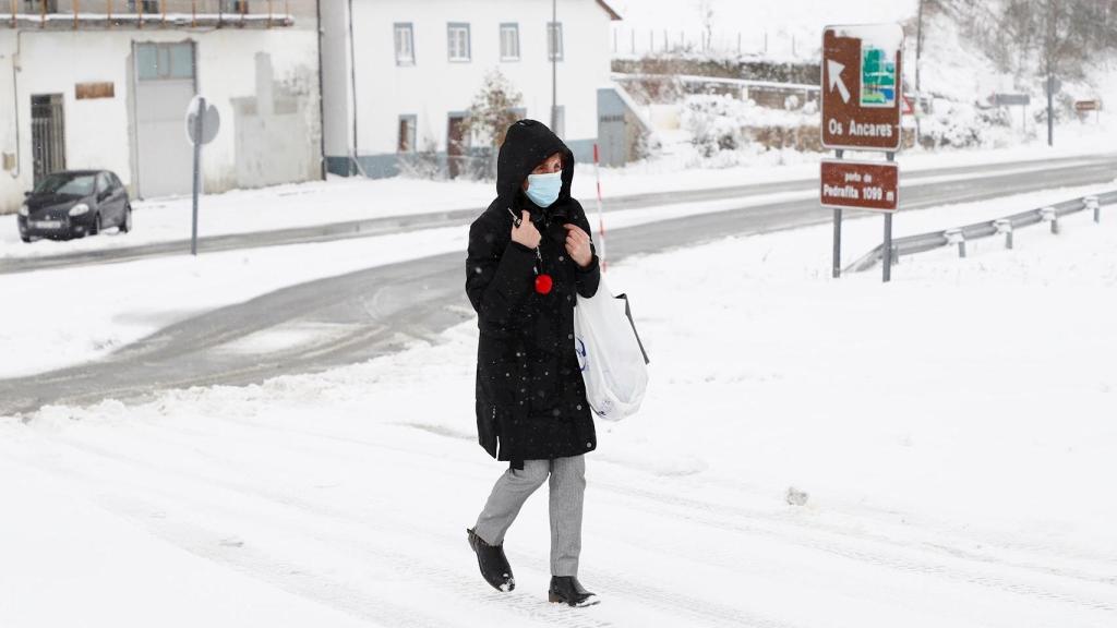 Una mujer camina por una calle de Pedrafita, en la montaña de Lugo. EFE/Eliseo Trigo.