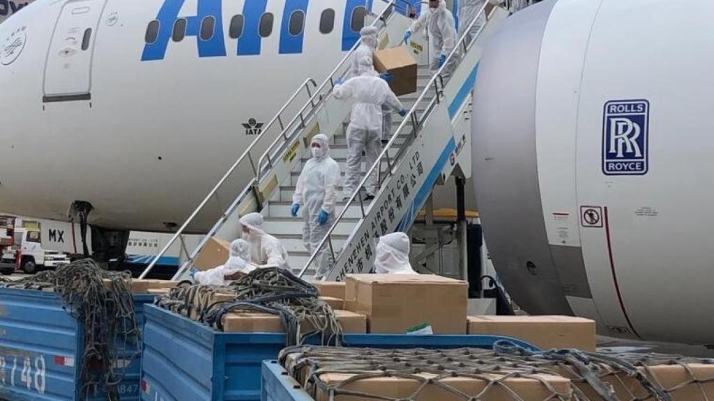 Operarios descargan material sanitario de un avión.