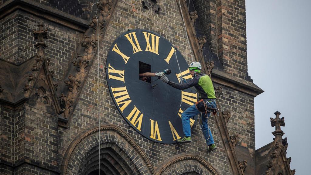 Un operario trabaja en el mantenimiento del reloj.