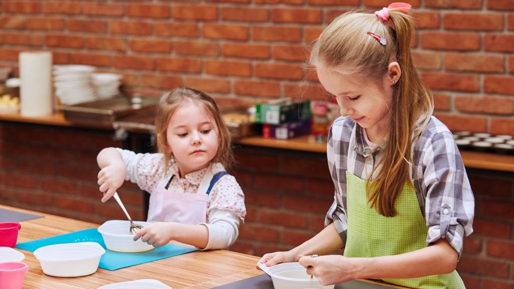 Dos niñas en un taller infantil de cocina.