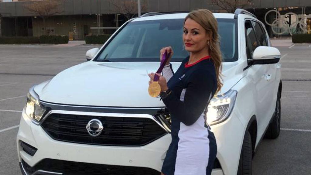 Lydia Valentín, campeona olímpica y mundial, muestra su medalla junto al coche.