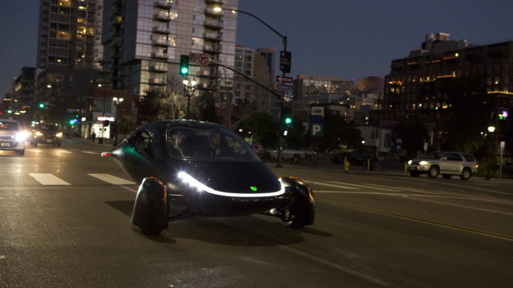 El coche solar de Aptera  circulando por las calles de una ciudad.