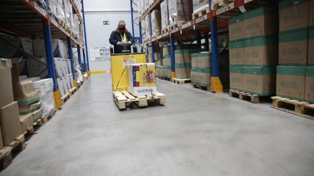 Un técnico de la Agencia Española del Medicamento y Productos Sanitarios transporta el priemr cargamento de vacunas en el almaén de Guadalajara.