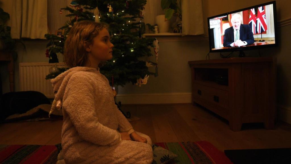 Una niña británica escucha el discurso del primer ministro del Reino Unido, Boris Johnson.