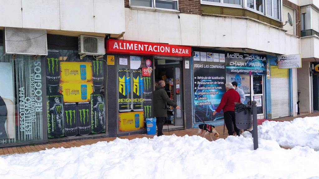Varios clientes a las puertas de una tienda dirigida por un joven de origen chino.