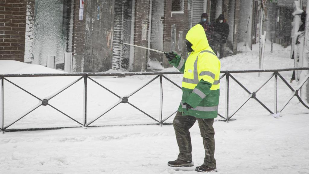 Un operario ayer, entre la nevada.