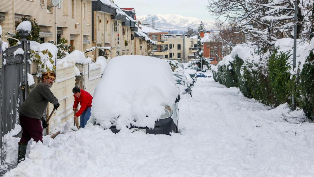 Dos personas despejan el camino con palas tras la nevada fruto del temporal Filomena, en Pozuelo de Alarcón (España).