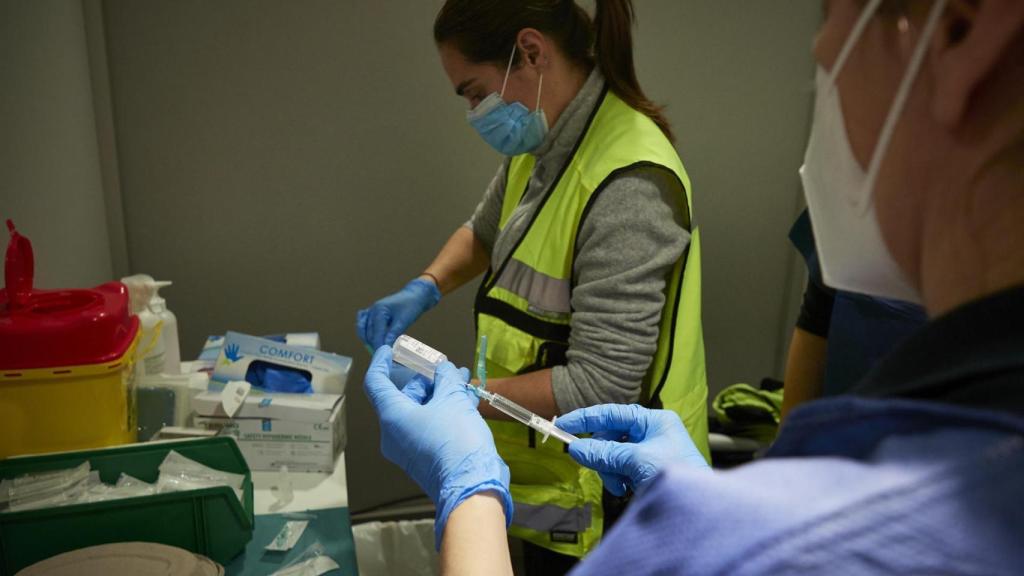 Varios sanitarios administran la vacuna.