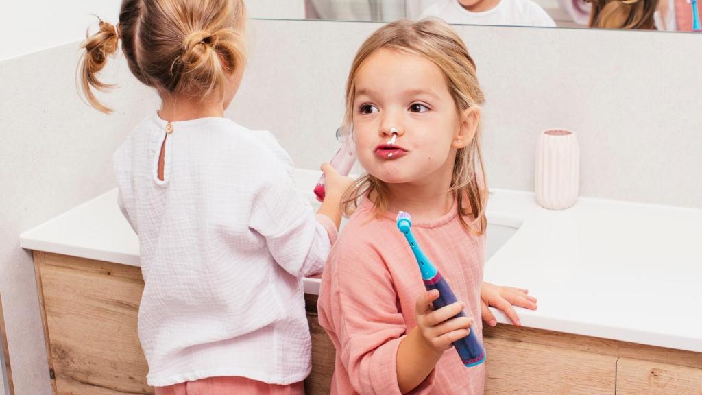 Dos niñas se cepillan los dientes