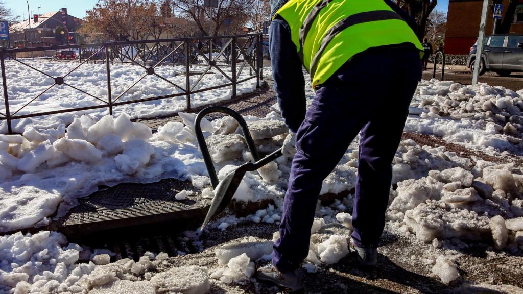 Un operario limpia nieve del alcantarillado de Madrid antes de que comiencen las lluvias en la capital, en Madrid (España), a 19 de enero de 2021.