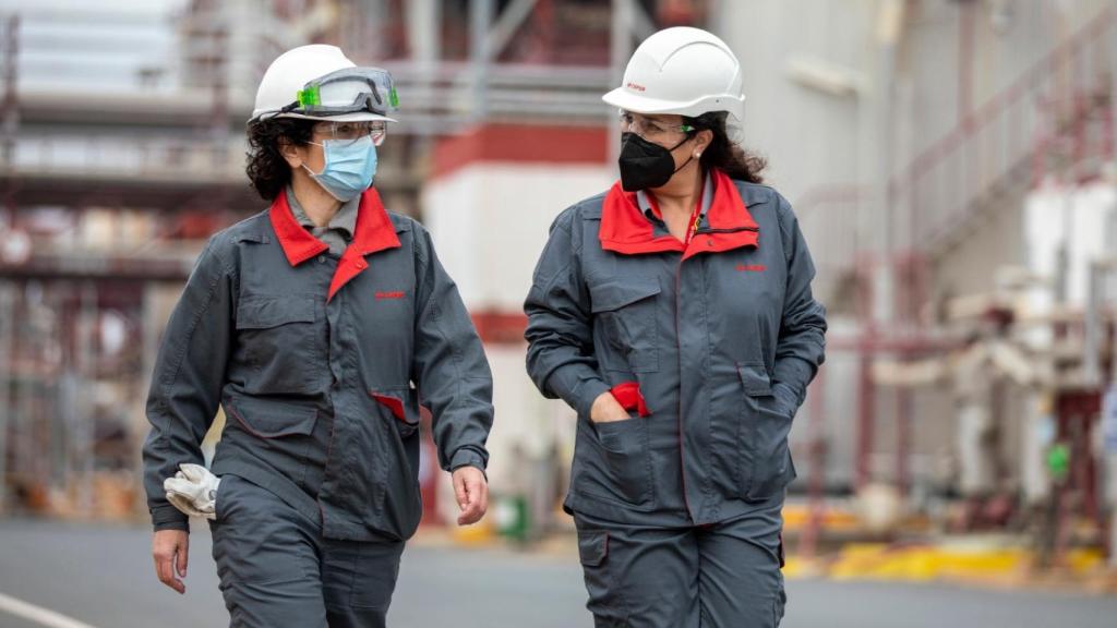 Esther González y una de las mujeres que ocupa un puesto de mano en la planta química.