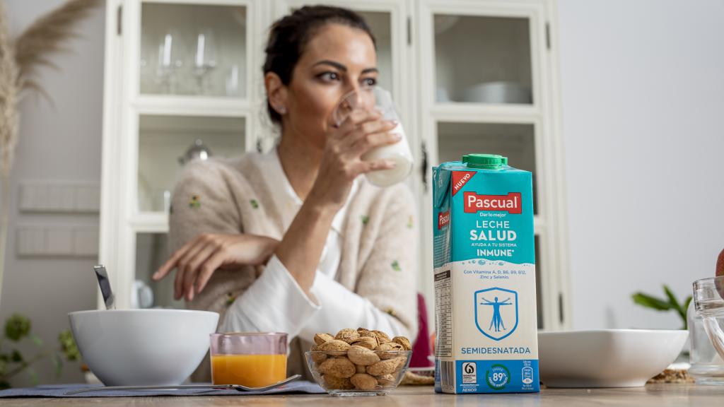 Una mujer tomando un vaso de leche Pascual Salud.
