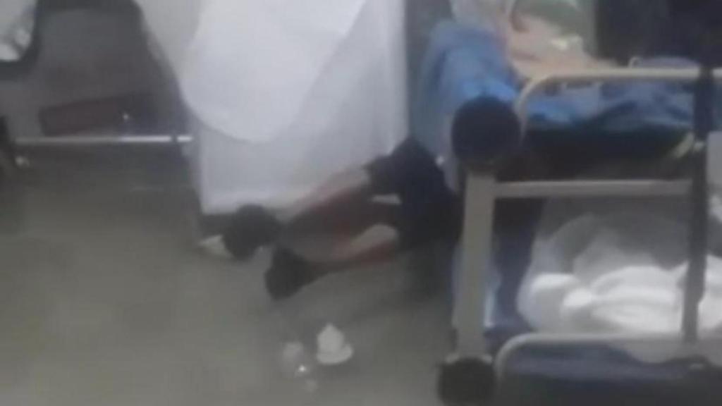 Uno de los migrantes levanta los pies para que no le alcance el agua