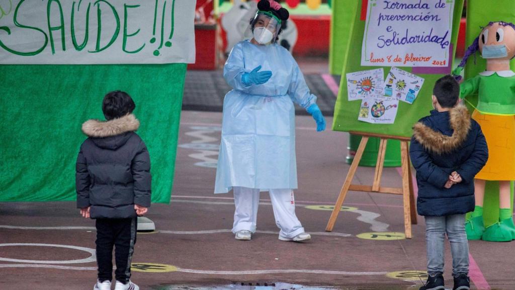Una sanitaria junto a unos niños durante un cribado masivo realizado en el centro educativo CEIP A Ponte.