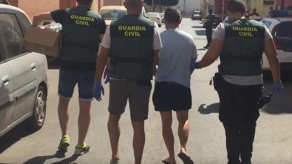 Agentes de la Unidad Orgánica de Policía Judicial custodiando a uno de los detenidos.