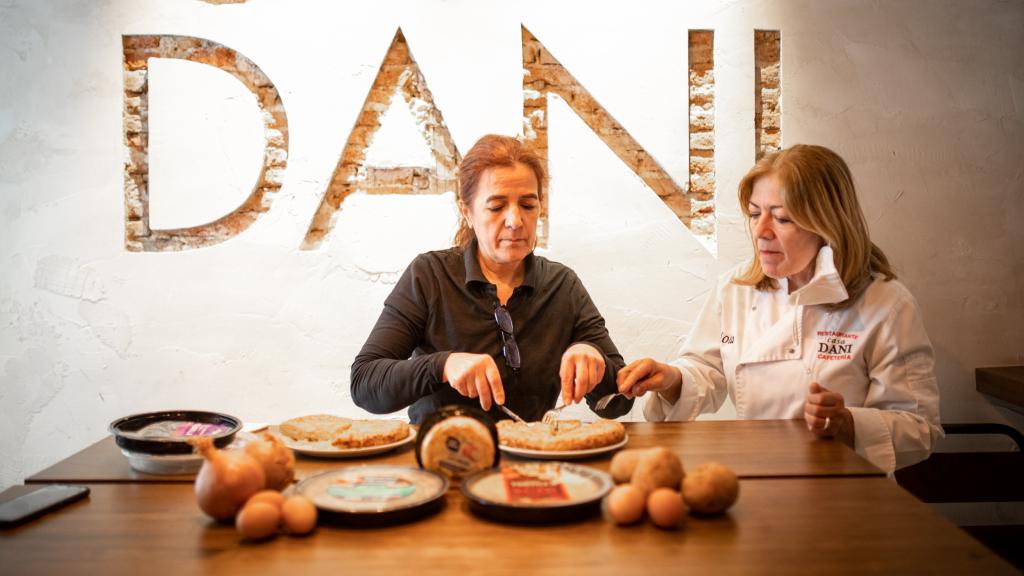 La cocinera experta en tortillas de patata, Teresa Cuerda, cortando una de las tortillas probadas mientras Lola observa.