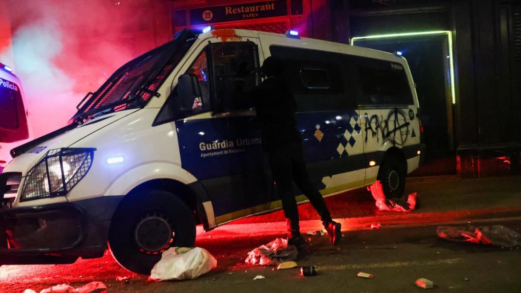 Un manifestante asalta una furgoneta de la Policía Urbana, en Barcelona.