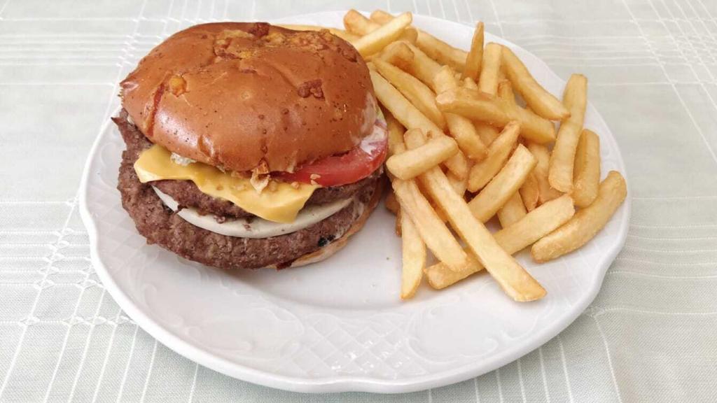La nueva hamburguesa de Burger King, la 'Queen Cheese', emplatada junto a unas patatas fritas.
