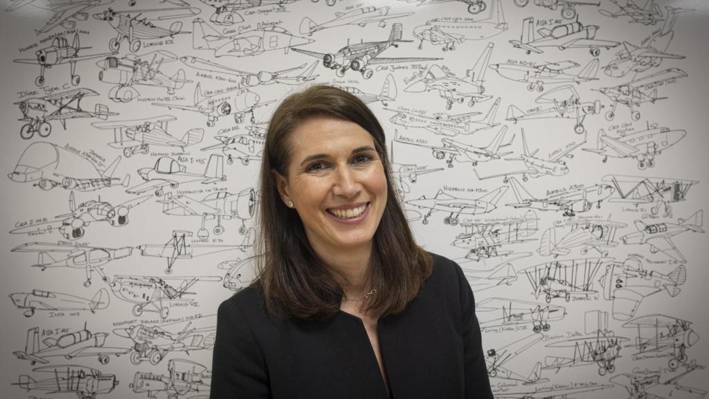 La ingeniera directiva de Airbus Paloma Peinado delante de un dibujo de todos los aviones en los que ha trabajado Airbus España.