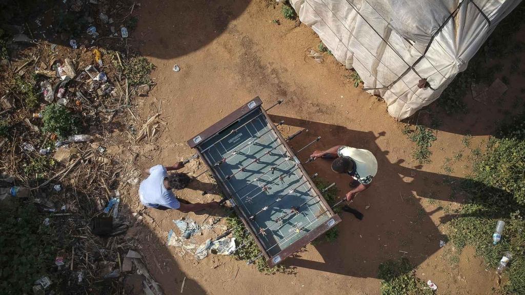 Los inmigrantes han instalado un pequeño futbolín en el campamento de Lepe (Huelva).