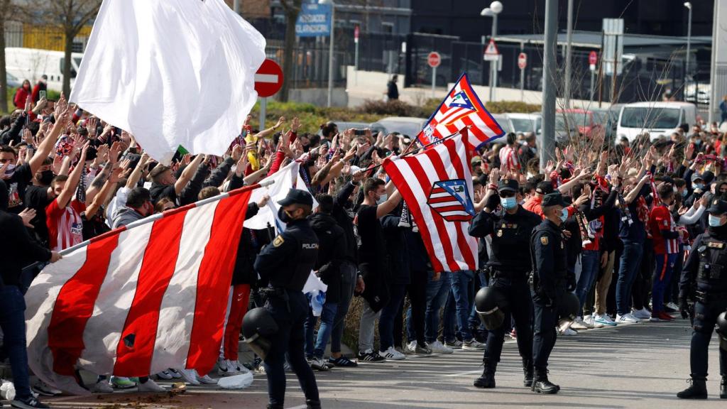 Seguidores del Atlético de Madrid y fuerte presencia policial en los alrededores del estadio Wanda Metropolitano en Madrid este domingo, antes del derbi liguero entre el Atlético de Madrid y el Real Madrid