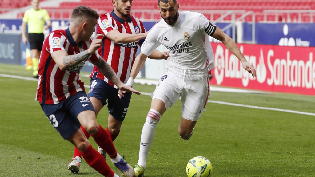 Karim Benzema perseguido por dos jugadores del Atlético de Madrid