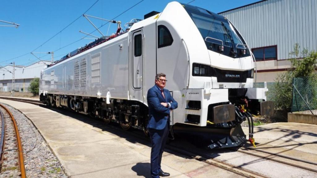 Íñigo Parra, presidente de Stadler Valencia, junto a una locomotora producida en la factoría. EE