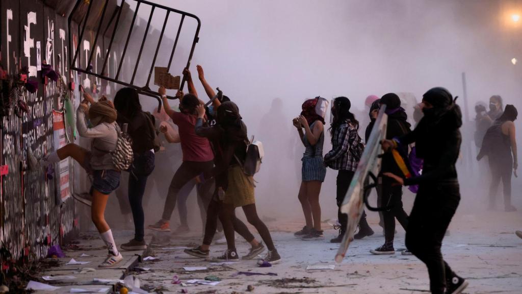 Manifestantes del 8-M en Ciudad de México tratan de acceder al Palacio Nacional.