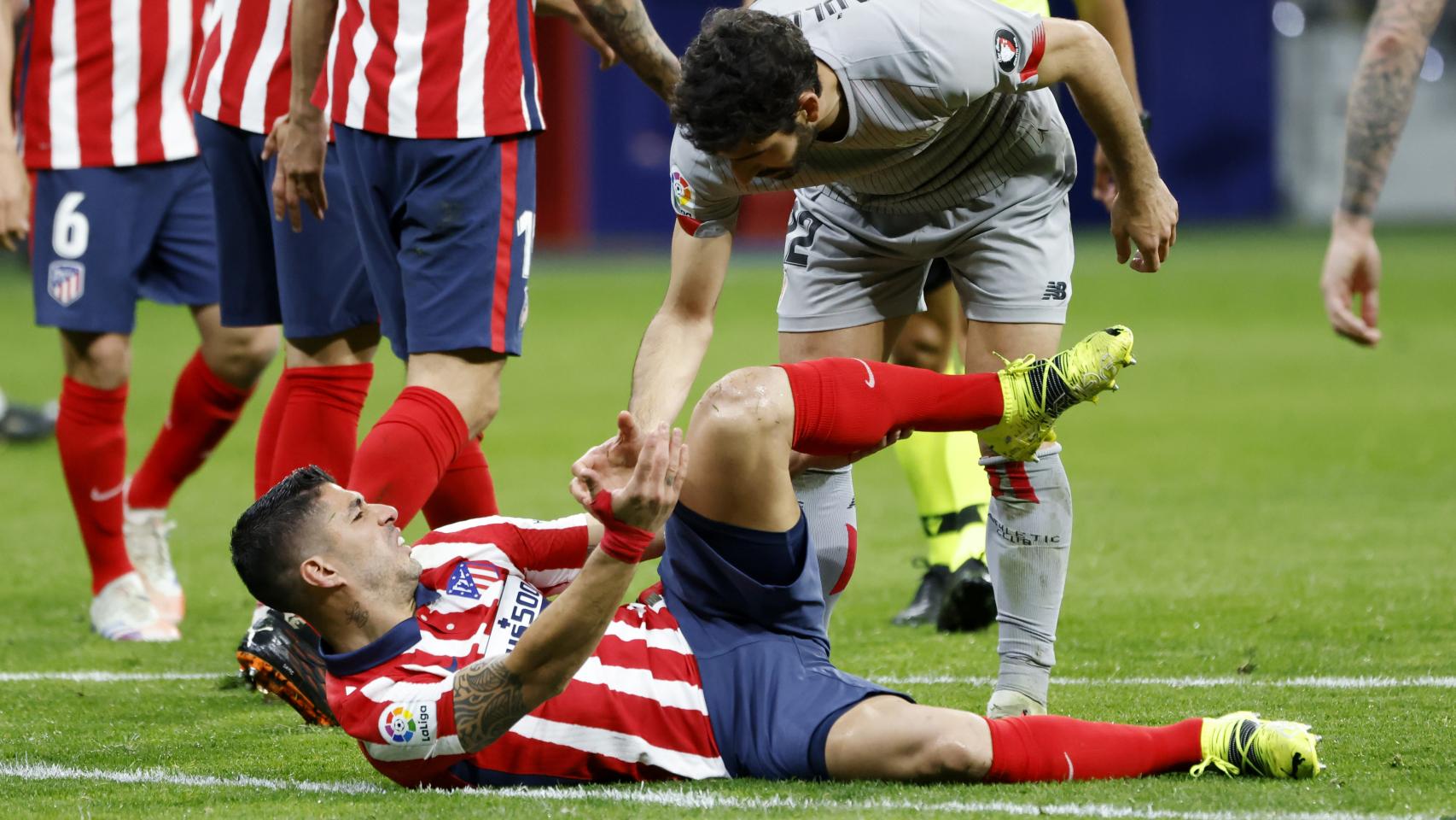 Raúl García ayuda a levantarse a Luis Suárez