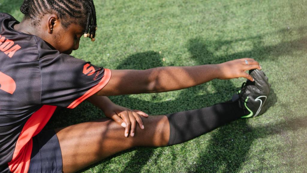 Una mujer calentando antes de un partido de fútbol