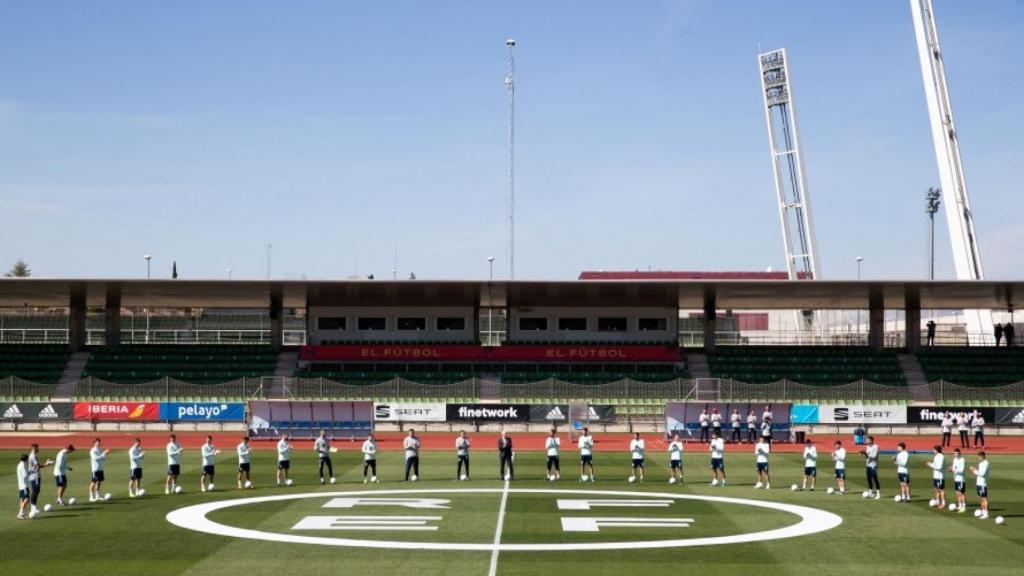 Los jugadores de la selección española y el nuevo logo de la RFEF