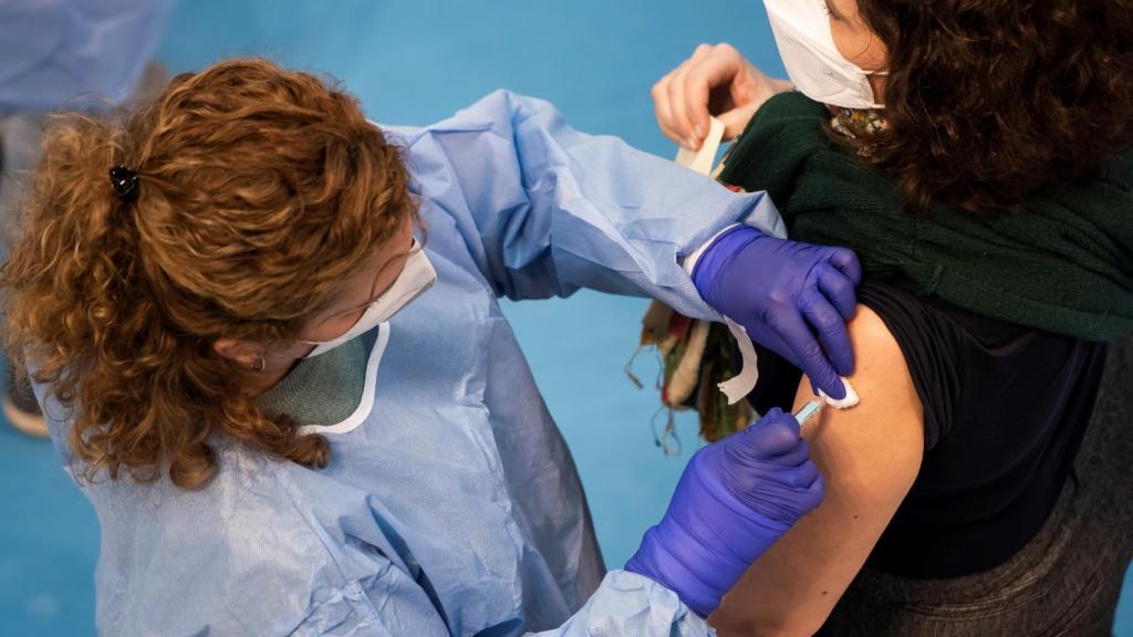 Una sanitaria vacuna a una mujer contra la Covid.