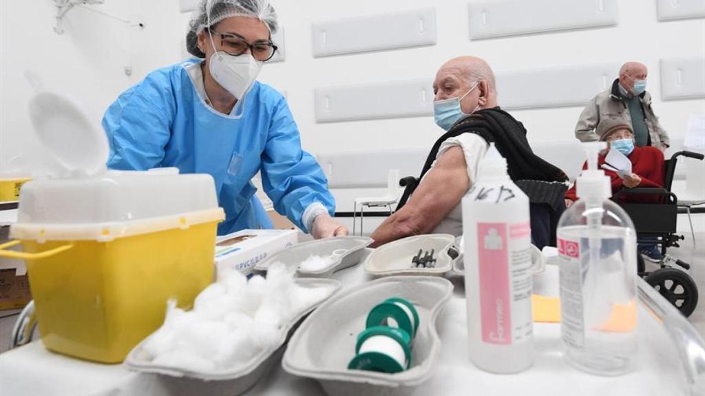 Una sanitaria vacuna a un hombre en Italia.