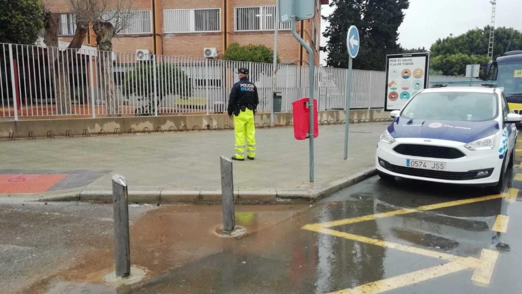 Un policía local de San Javier custodiando la puerta de acceso al IES Ruiz de Alda tras la amenaza de bomba.