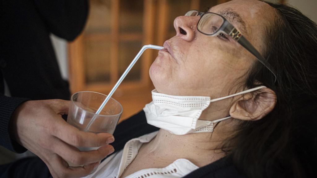 María Isabel Ruiz bebe agua con pajita, ayudada por una enfermera, este miércoles.