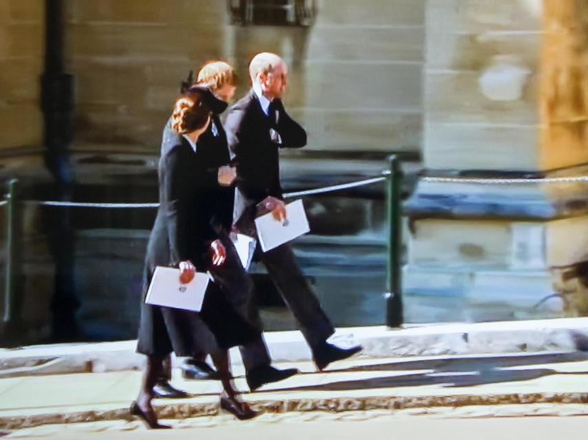 Los príncipes Guillermo y Harry hablando a la salida del sepelio. A su lado, Kate Middleton.